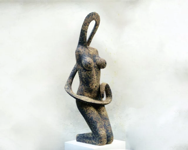 scultura in gres dello scultore ylli plaka. figura femminile e sinuosa fotografata su sfondo bianco